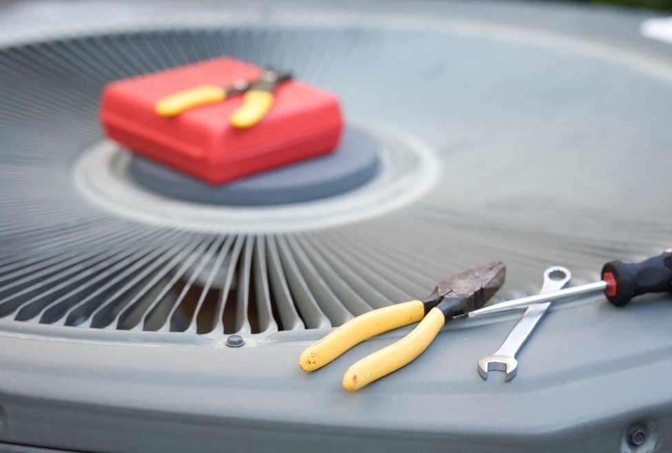 Close-up of an air conditioner with HVAC technician tools on top, representing AC not turning on, common air conditioner repair issues, and HVAC diagnostic services by Arctic Air including AC repair, system troubleshooting, and emergency cooling service. We provide help with AC not turning on, air conditioner won’t start, why is my AC not working, HVAC not turning on, AC won’t kick on, air conditioning repair near me, emergency AC repair near me, thermostat not working with AC, air conditioner troubleshooting, HVAC repair services, cooling system won’t turn on, AC system reset, air conditioner electrical problems, HVAC fuse blown, AC capacitor replacement, air conditioner repair Palmdale, AC services in Lancaster, residential HVAC repair near me, central AC not starting, Arctic Air HVAC repair, HVAC troubleshooting services, AC won’t power on, broken air conditioner fix, air conditioner maintenance near me.