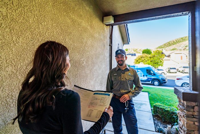 Arctic Air & Plumbing technician explaining a brochure to a customer