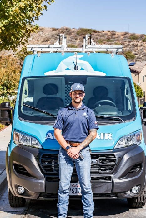 Arctic Air technician standing in front of his work van